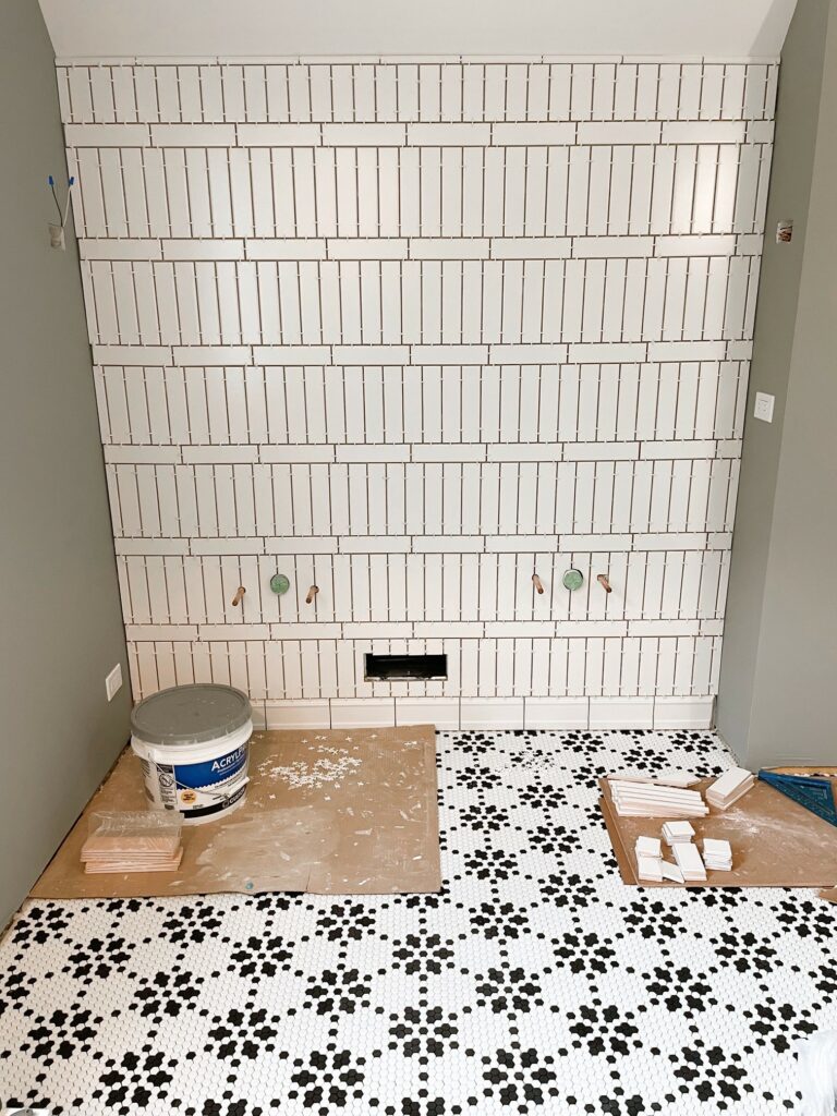 In progress tiling project of walls and bathroom floor.