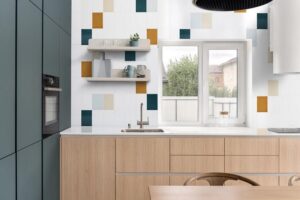 Modern and bright kitchen with minimalist cabinetry and colorful subway tile.