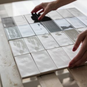 Tile professional comparing different shades and materials of tile for project.