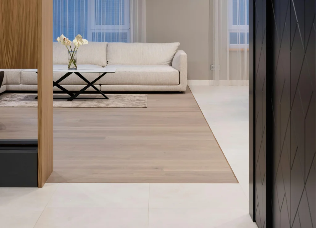 Modern living room with wood look tile transitioning to white tile