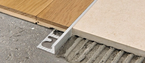 Metal tile transition strip between wood and tile flooring