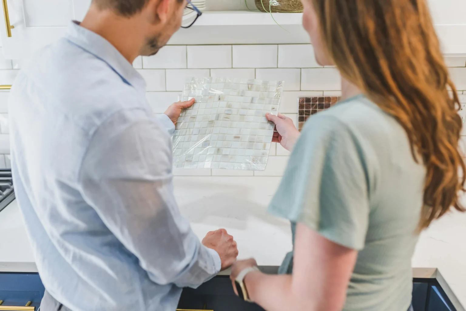 young couple looking at samples to choose a tile layout pattern