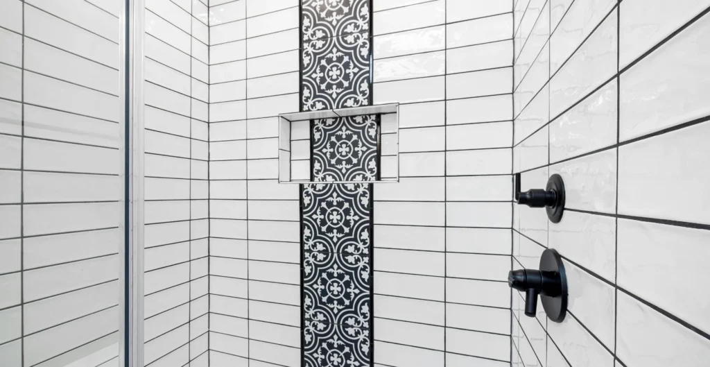 Straight stack tile layout in a shower with white tile and black grout