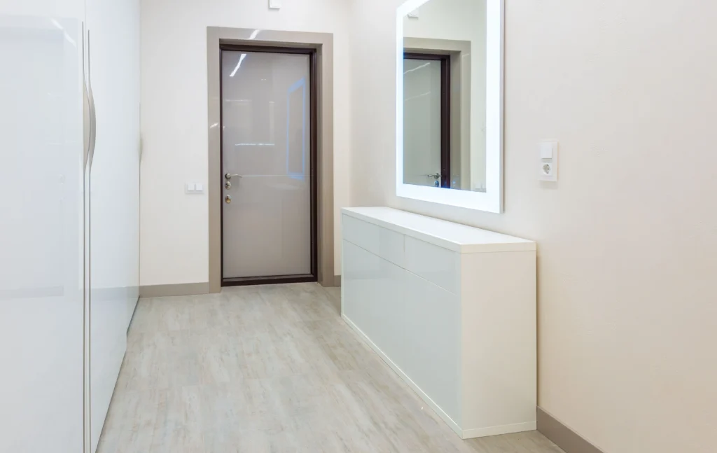 narrow entryway with light tan woodgrain tile
