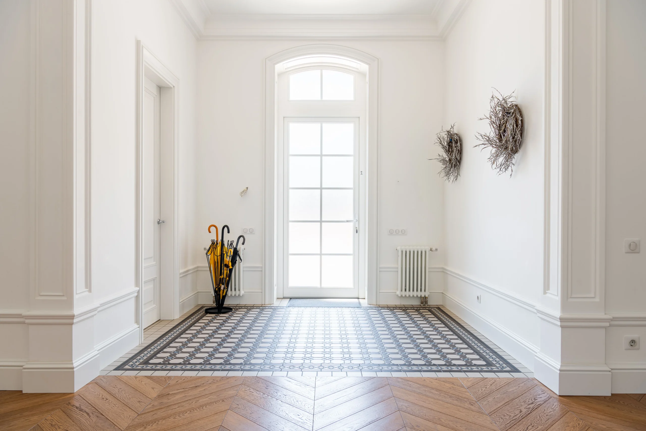Formal entryway with checkerboard tile transitioning to wood flooring
